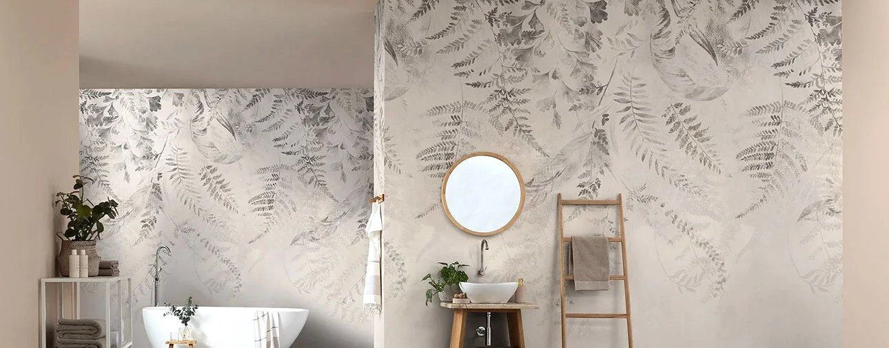 Botanical wallpaper with pale leaf patterns around a bathtub and bathroom vanity